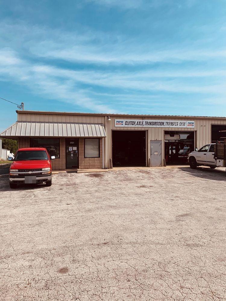 The CATT shop on E Kearney Street, two bay doors open with a vehicle up on the lift